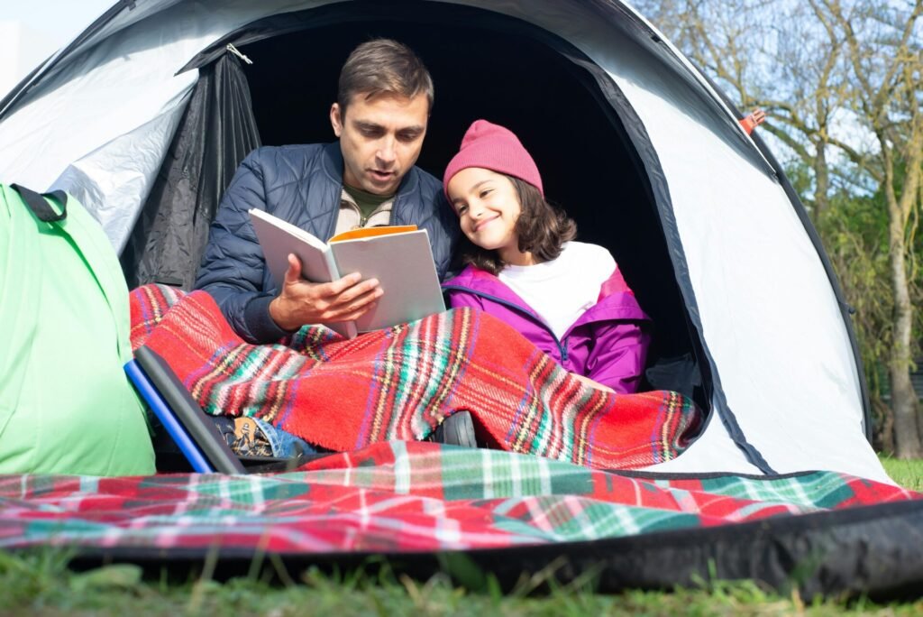 7 Exciting Family Goals to Infuse Happiness into Everyday 4 Backyard Camping, a man reading book with a little girl