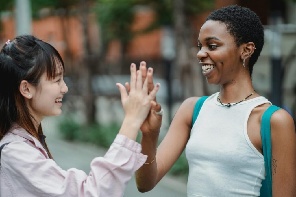 two students smiling loud and doing high five