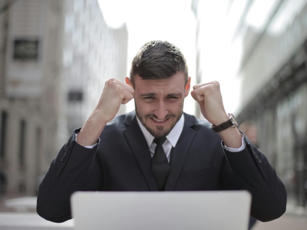 Man happy with Sense of Accomplishment in front of laptop