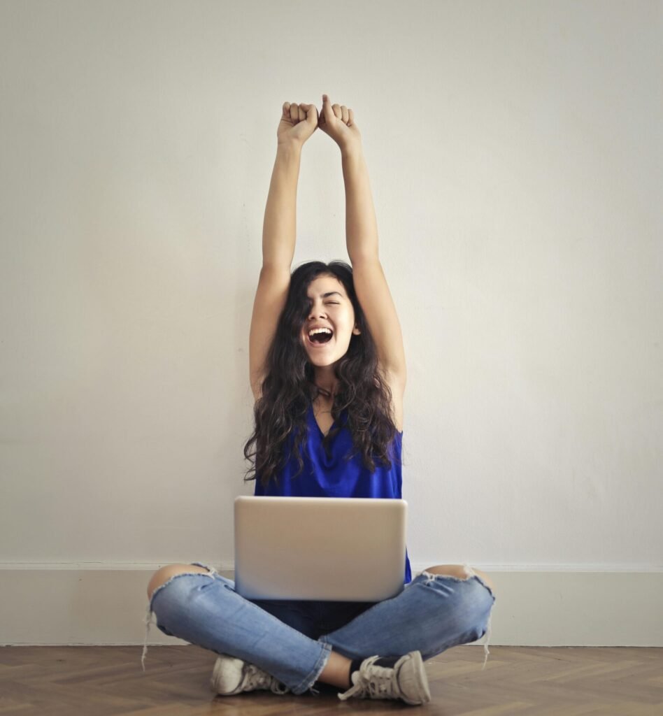 girl doing stretches with laptop on the lap 